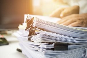 Businessman hands searching data information in Stack of papers files on work desk in office, business report paper or piles of unfinished documents achives with clips on offices indoor, Business concept | hold an HOA board election