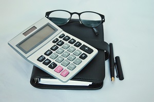 eyeglasses, notebook and pen with calculator on top | hoa treasurer report