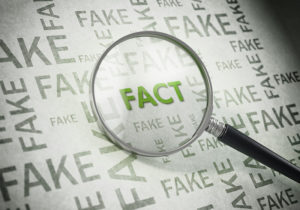 Magnifying glass on green fact text standing out from fake words | hoa neighbor harassment